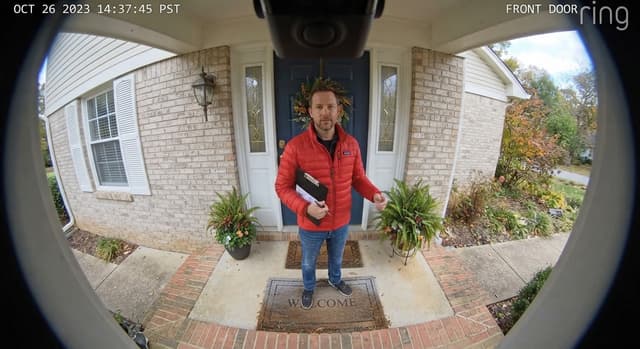 Live camera view of the front door, showing a person waiting outside